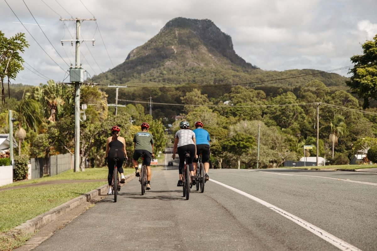 Cyclist overlooking ancient volcanic peaks on a Noosa gravel ride
