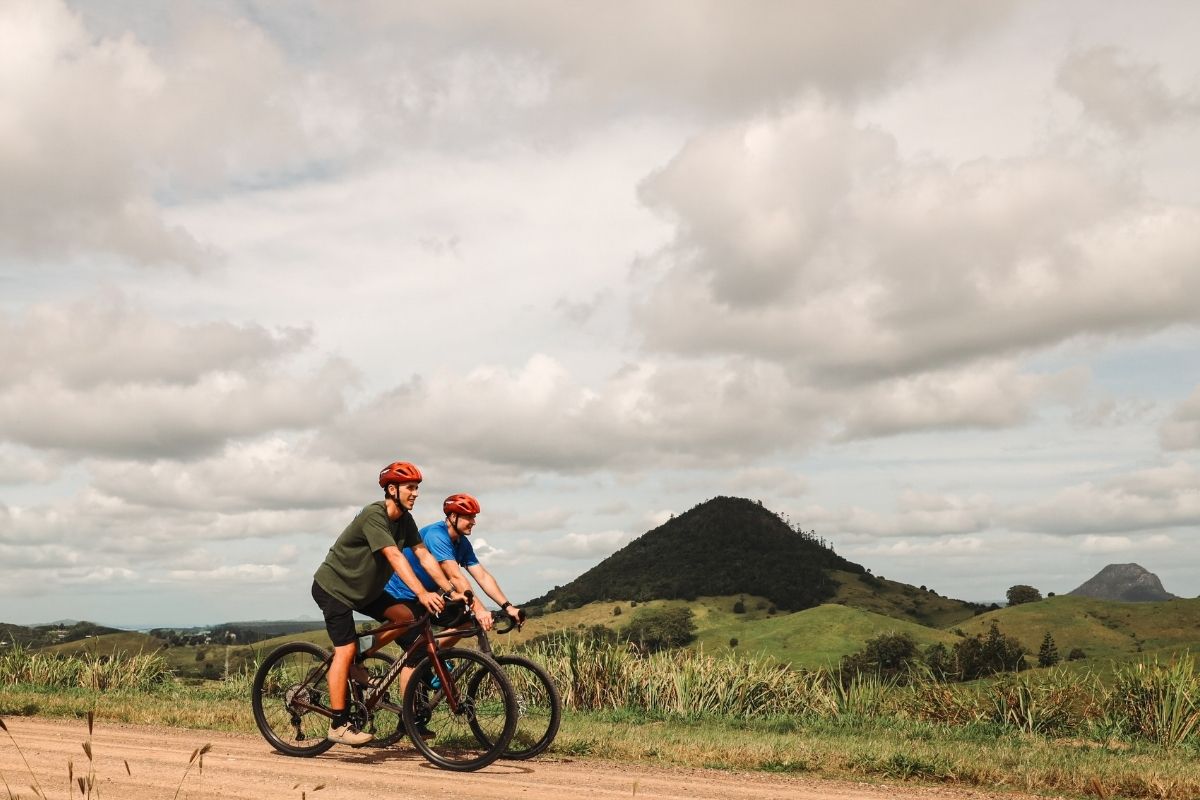 Gravel cyclist riding through rolling farmland in the Noosa Hinterland