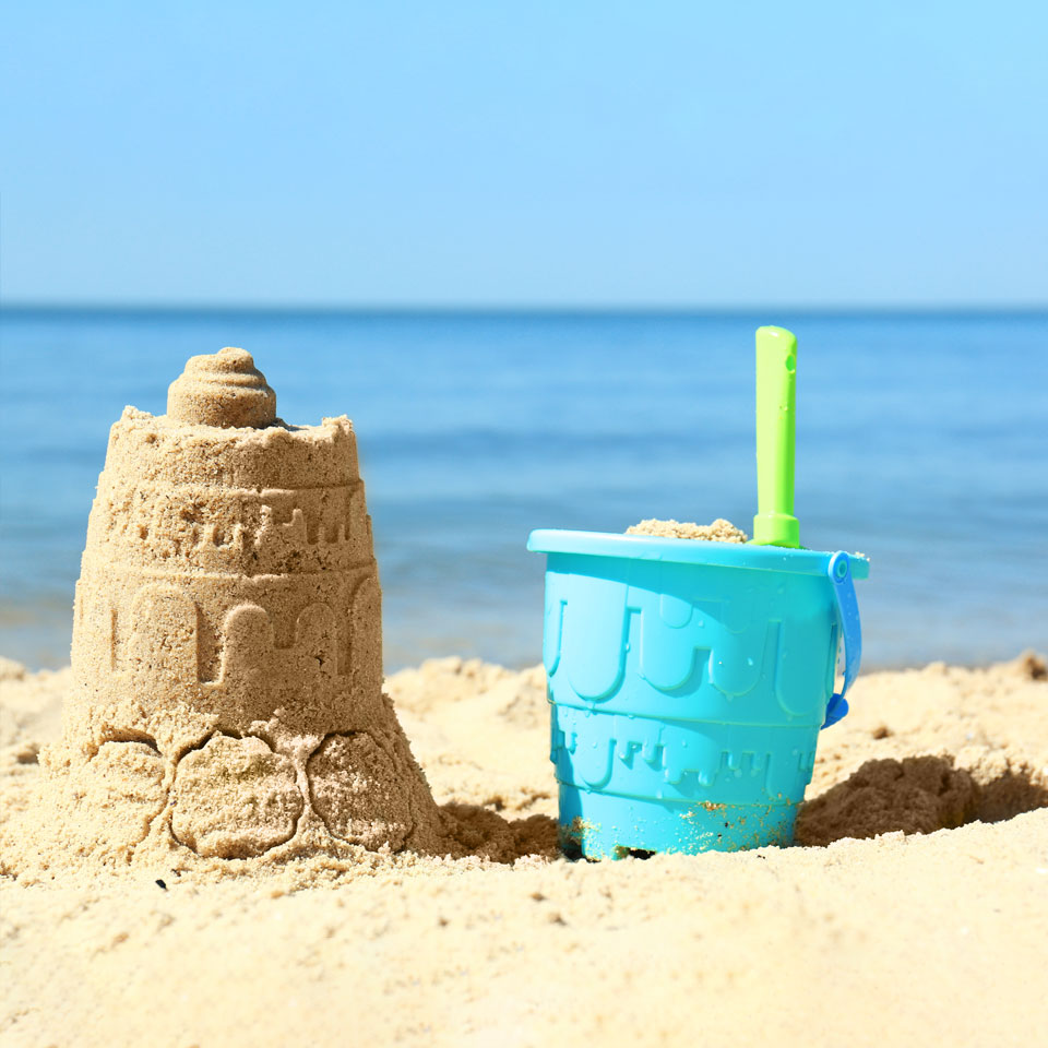 Sandcastle with a bucket and spade on the beach