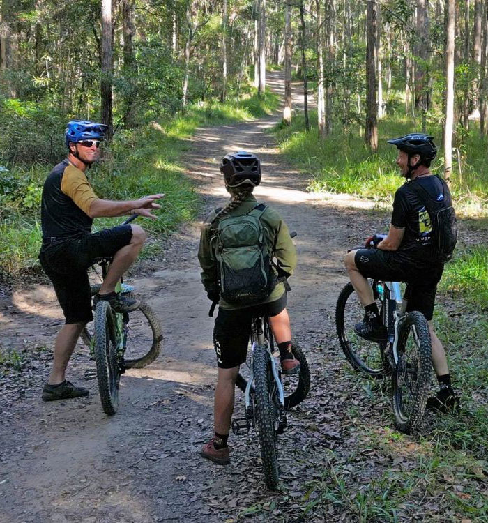 PMBIA qualified Bike On coach leading riders on a forest trail